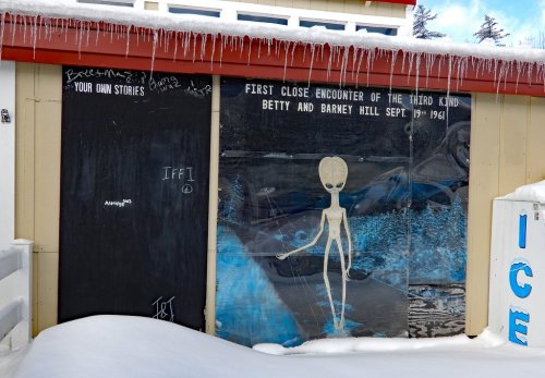 Mural depicting an alien with text about the Betty and Barney Hill abduction, surrounded by snow and icicles.