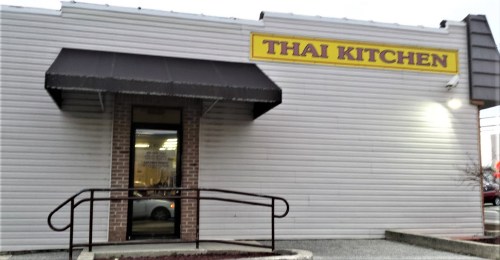 Exterior of a restaurant building with a sign that reads "Thai Kitchen" and a wheelchair-accessible entrance.