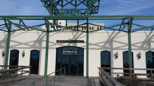 Entrance of the Galveston Railway Express Agency, featuring a green metal structure and a wooden walkway.