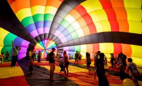 A colorful hot air balloon interior with people walking and enjoying the vibrant patterns.