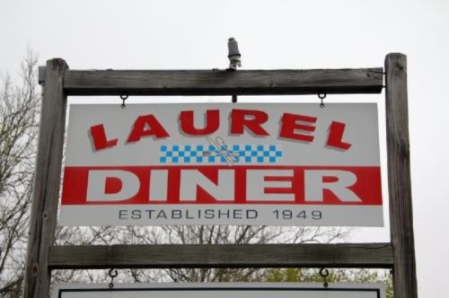 Sign for Laurel Diner, established in 1949, featuring red and blue lettering on a wooden post.