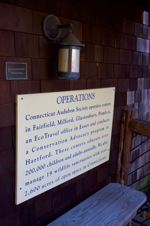 Sign detailing the operations of the Connecticut Audubon Society, including locations and educational programs.