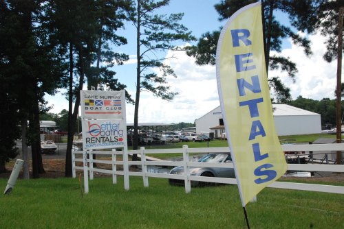 Signage for Lake Murray Boat Club with a "Rentals" flag and information about boat and paddle sports rentals.