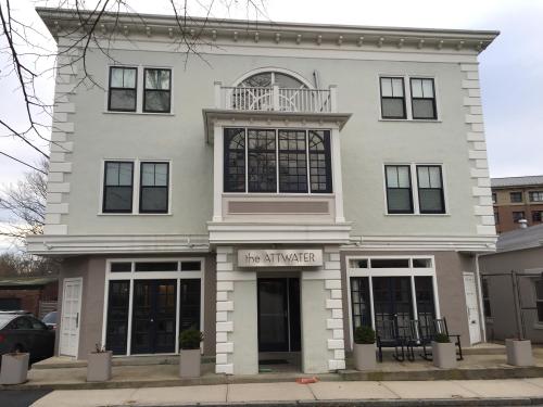 A three-story building with a light gray facade, large windows, and a sign reading "the ATTWATER" at the entrance.