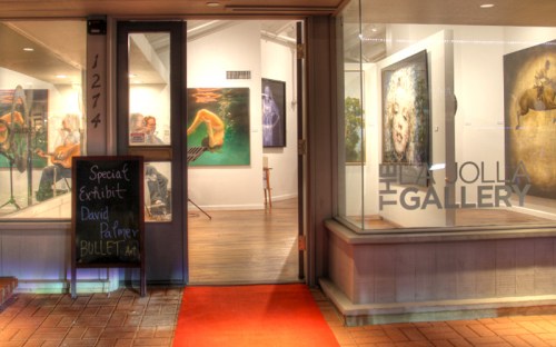 Entrance to La Jolla Gallery featuring a special exhibit by David Palmer, with artwork visible through the windows.