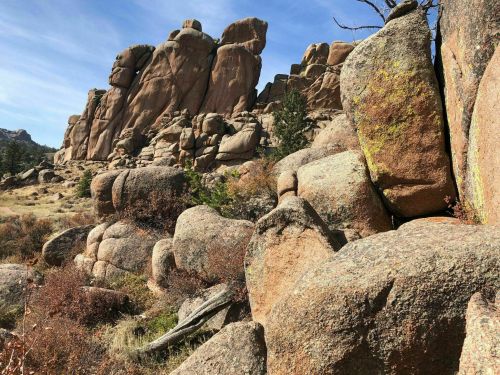 Rocky landscape featuring large boulders and rugged formations under a clear blue sky.