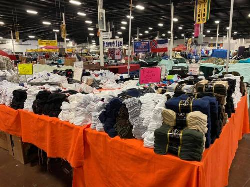A vibrant market stall displaying neatly stacked socks in various colors on an orange tablecloth.