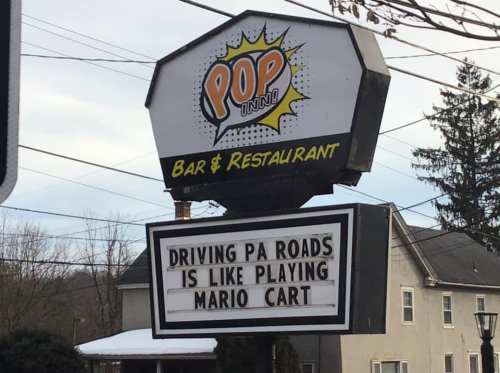 Sign outside a bar and restaurant reads: "Driving PA roads is like playing Mario Kart."