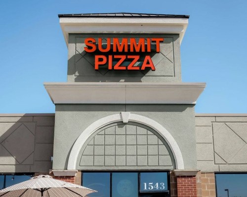 Sign for Summit Pizza on a building with a clear blue sky in the background.