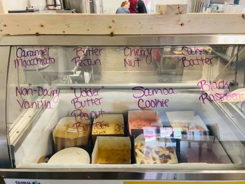 Ice cream display case with various flavors labeled, including Caramel Macchiato, Butter Pecan, and Samoa Cookie.