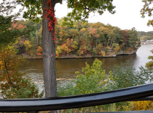 Scenic view of a river surrounded by colorful autumn foliage and trees.