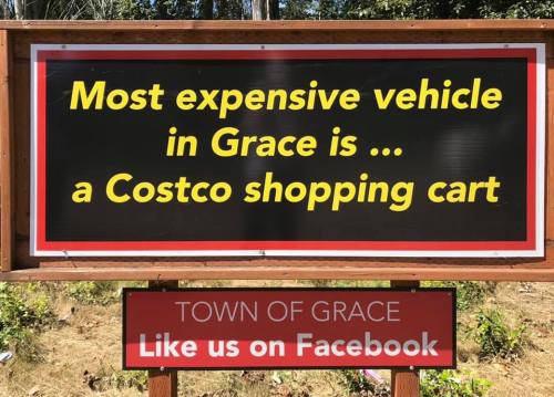 Sign humorously states, "Most expensive vehicle in Grace is ... a Costco shopping cart," with a Facebook promotion below.