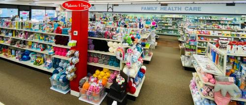 A colorful retail space filled with shelves of toys, crafts, and health care products, labeled "Family Health Care."