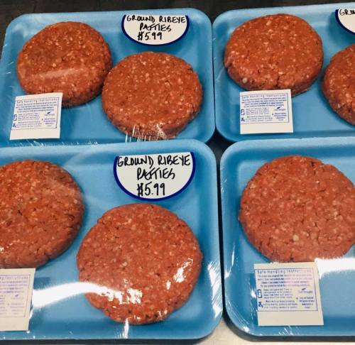Six packages of ground ribeye patties on blue trays, each labeled with a price of $5.99.