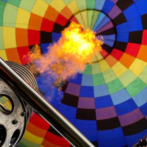 A colorful hot air balloon interior with flames shooting from the burner, creating a vibrant display.