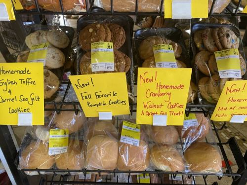 A display of homemade cookies with labels for English Toffee, Carmel Sea Salt, Pumpkin, Cranberry Walnut, and more.