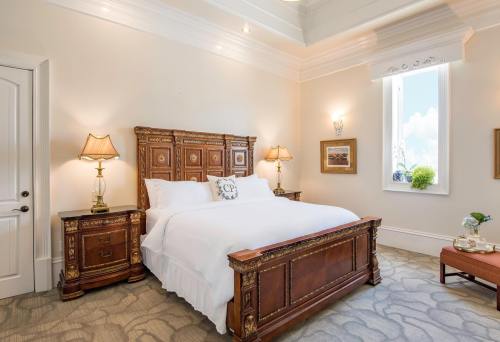 Elegant bedroom featuring a wooden bed, bedside tables with lamps, and soft lighting, creating a cozy atmosphere.