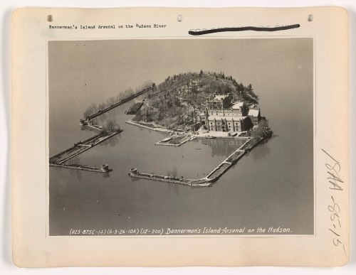 Aerial view of Bannerman's Island Arsenal on the Hudson River, featuring buildings and surrounding water.