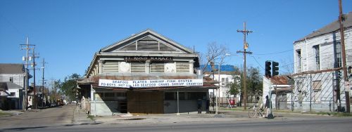 Abandoned seafood market building with a weathered sign, surrounded by empty streets and power lines.