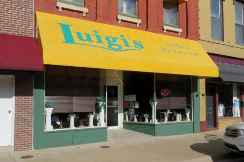 A storefront of Luigi's Italian Restaurant with a bright yellow awning and "OPEN" sign in the window.