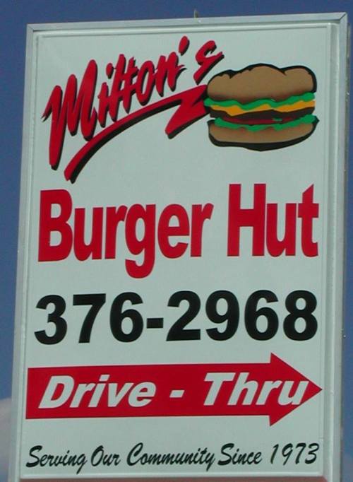 Sign for Milton's Burger Hut featuring a burger graphic, phone number, and "Drive-Thru" direction. Established 1973.