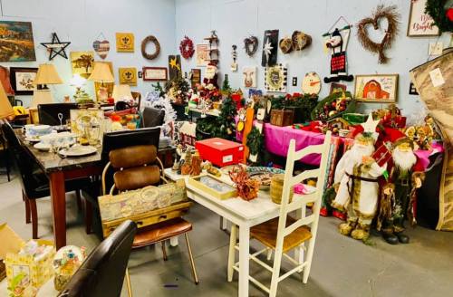 A cluttered room filled with various items, including furniture, decorations, and holiday-themed objects.