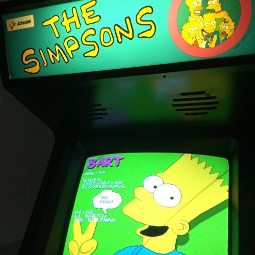 Arcade cabinet for "The Simpsons" game featuring Bart Simpson on the screen with his age and a playful message.