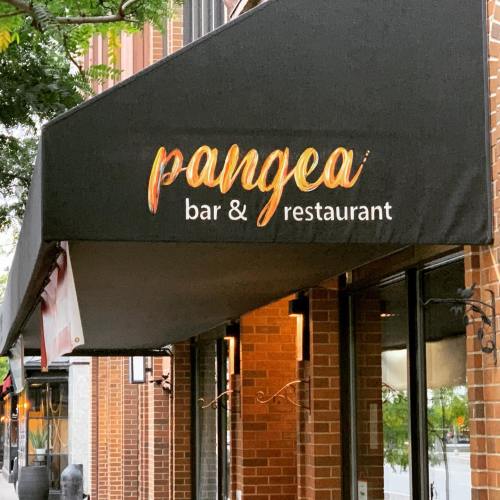 Sign for "Pangea Bar & Restaurant" displayed on a black awning above a brick building entrance.