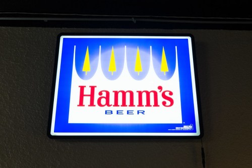Neon sign for Hamm's Beer featuring a blue background and stylized trees above the brand name.