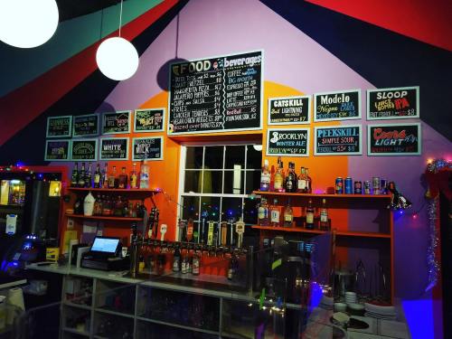 Colorful bar with a menu board, drinks, and festive decorations in a cozy setting.