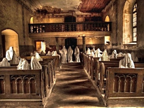 A dimly lit, abandoned church with ghostly figures in white robes seated in wooden pews.