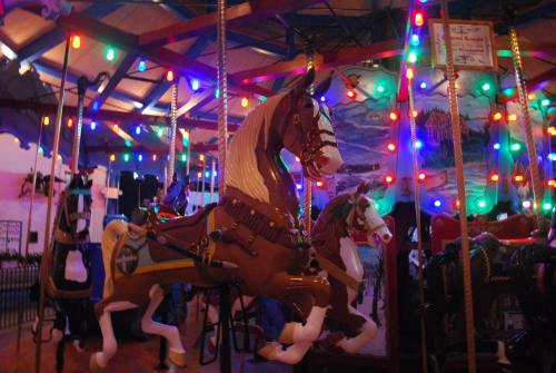 A colorful carousel with illuminated lights and intricately designed horse figures.