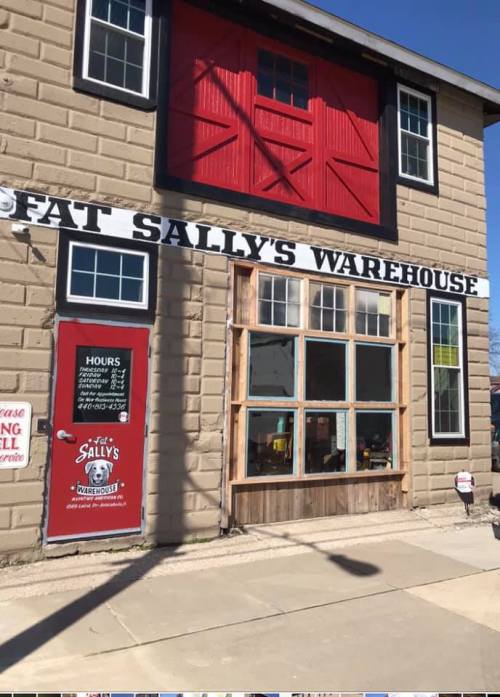 Exterior of Fat Sally's Warehouse, featuring a red and black facade with large windows and a welcoming entrance.