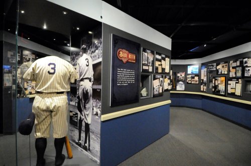 A museum exhibit featuring baseball memorabilia, including a large display of Babe Ruth and various historical artifacts.