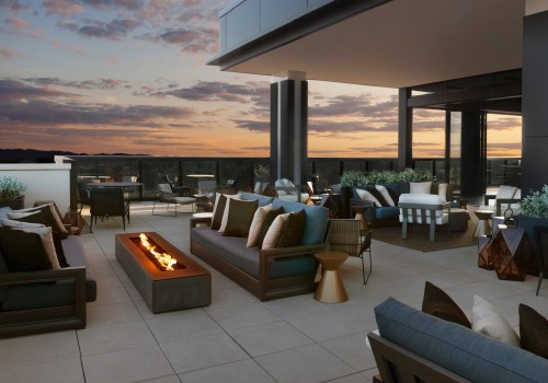 A stylish rooftop patio with modern seating, a fire pit, and a sunset view, creating a cozy outdoor atmosphere.