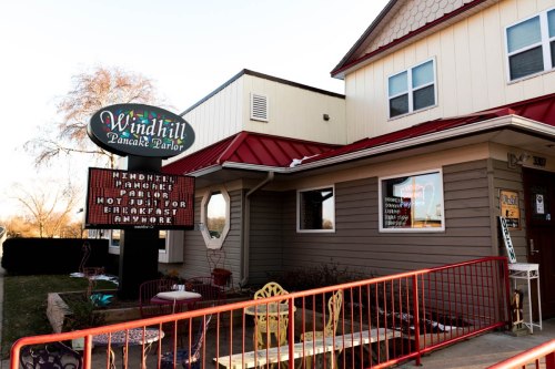 Sign for Windhill Pancake Parlor, featuring a red roof and outdoor seating area.