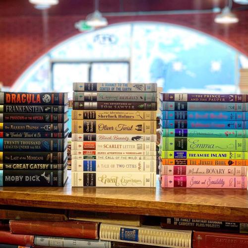 A collection of classic literature books displayed on shelves, featuring titles like "Dracula," "Moby Dick," and "Emma."