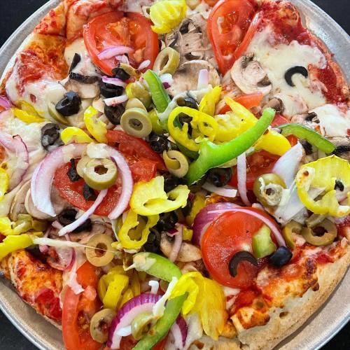 A colorful pizza topped with tomatoes, mushrooms, olives, green peppers, onions, and banana peppers on a thin crust.