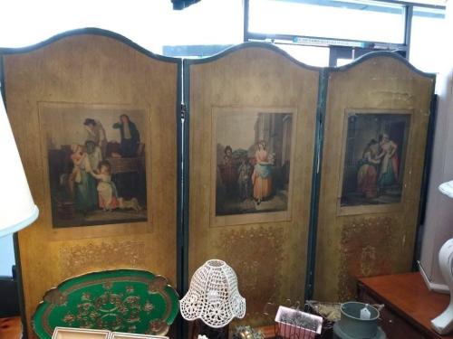 A vintage three-panel screen featuring ornate designs and classical paintings on each panel.