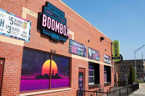 Exterior of Boombox Social, featuring colorful signage and a vibrant retro design, with outdoor seating available.
