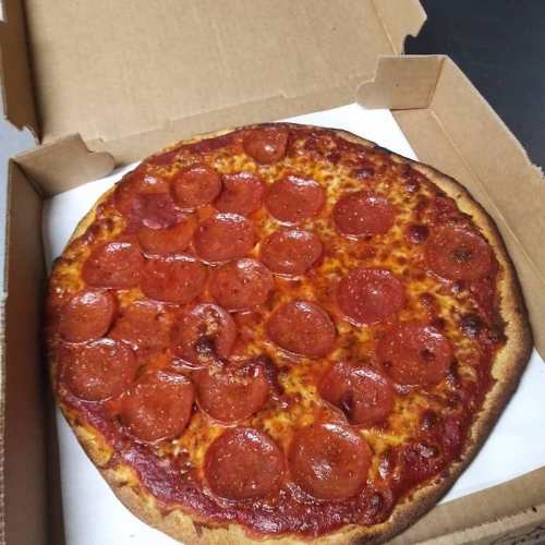 A pepperoni pizza in a cardboard box, featuring a golden crust and melted cheese.