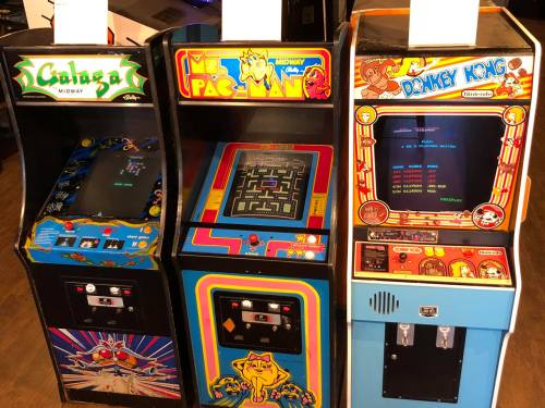 Three classic arcade machines: Galaga, Ms. Pac-Man, and Donkey Kong, featuring colorful artwork and screens.