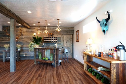 Cozy interior of a rustic space featuring wooden decor, a reception desk, and decorative antlers on the wall.