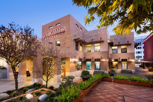 Exterior of Vroman's Bookstore, featuring warm lighting, greenery, and a charming architectural design at dusk.