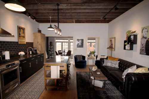 A stylish open-concept living space featuring a kitchen, dining area, and cozy seating with modern decor.