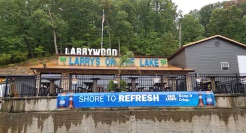 A lakeside restaurant named "Larry's on the Lake" with outdoor seating and a banner promoting Bud Light.