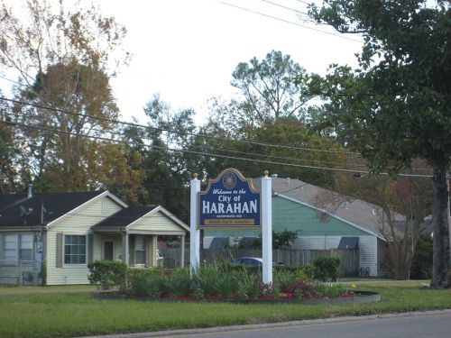 Welcome sign for the City of Harahan, surrounded by residential homes and greenery.