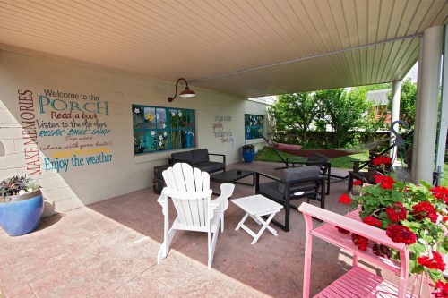 A cozy porch with seating, colorful decor, and potted plants, inviting relaxation and enjoyment of the outdoors.