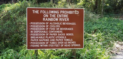 Sign listing prohibited items on the Rainbow River, including alcohol, food, and fishing restrictions.