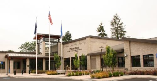 Exterior view of the City of Keizer building, featuring flags and landscaped greenery.